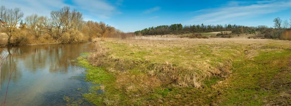 Spring landscape panoramic view with river and meadow, early spring Stock Photos