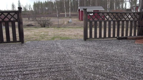 Spring light hail storm on wet wooden terrace covered by white round frozen h Stock Footage 141079064