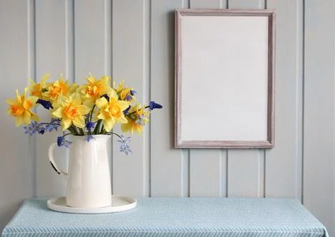 Spring mockup. an empty frame on the wall in the cottage and a bouquet of g.. Stock Photos
