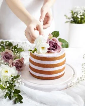 Spring mood. Sponge cake with whipped cream decorated with delicate flowers. A Stock Photos