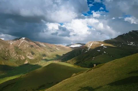 Spring mountains with snow and cloudy sky Stock Photos