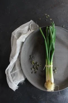 Spring onions on dark table background top Foto stock