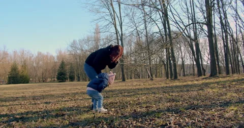 Spring in the park. A young mother is playing with her little girl. Stock Footage 151552365