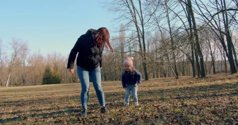 Spring in the park. A young mother is playing with her little girl. Stock Footage 151553092