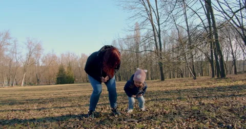 Spring in the park. A young mother is playing with her little girl. Stock Footage 151553390