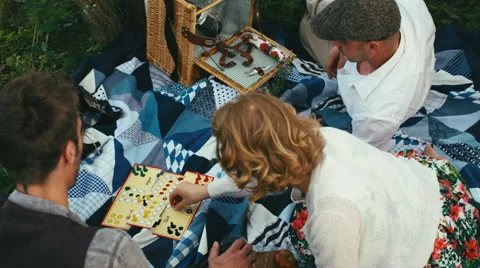 Spring Picnic in Meadow - Three Friends Playing Board Game Together Video stock 50221017