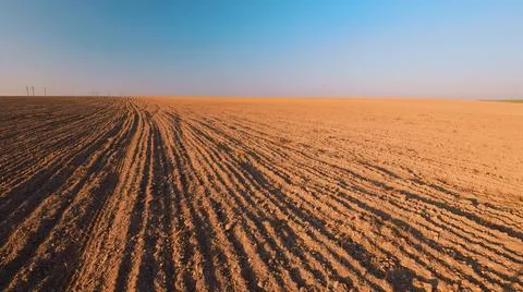 Spring Plowed Field In Sunset Light. Ploughed Field In Early Spring. Farm Stock Photos