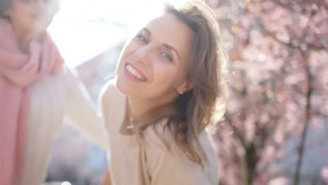 Spring portrait of two women on a background of a blossoming magnolia. Mother's Stock Footage 107651645