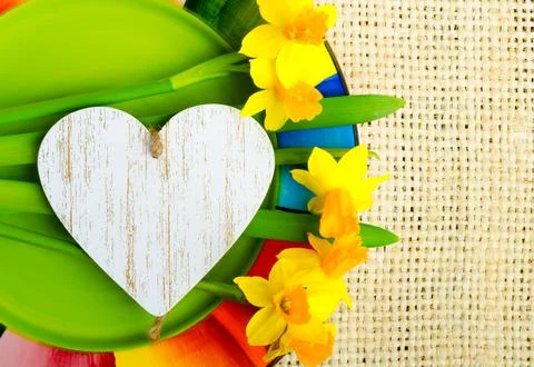Spring primroses daffodils on a multi-colored plate against the background of Stock Photos
