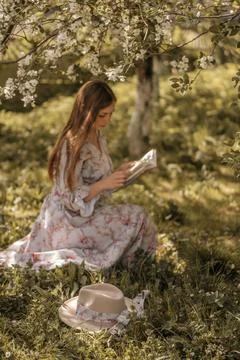 Spring Reading in Blooming Meadow Foto stock