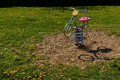 Spring rider on empty green playground 写真素材