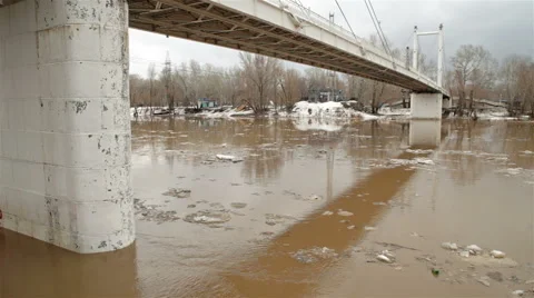 Spring river with dirty brown water and ice. floating of ice and bridge Stock Footage 65116494