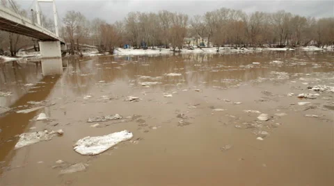 Spring river with dirty brown water and ice. floating of ice Video stock 65286078