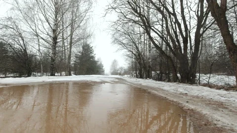 Spring road drops of melted snow fall into a puddle, gray rainy day, gloomy, Stock Footage 149679739