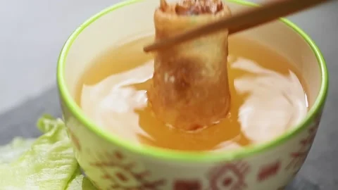 Spring roll is dipped in sauce, slow motion. Stock-Footage 165623045