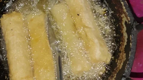 Spring rolls deep frying in hot bubbling oil in a pan Stock Footage 344356527