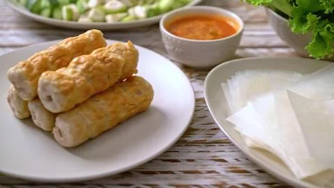 Spring rolls with dipping sauce on a rustic outdoor table Stock Photos