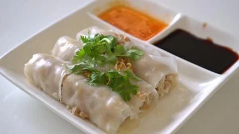 Spring rolls with herbs and dipping sauces on white plate Stock Photos