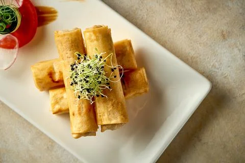 Spring rolls with meat fried in a deep fryer. Close-up, post-production noise Stock Photos