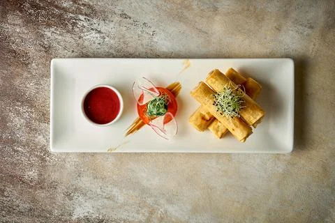 Spring rolls with meat fried in a deep fryer. Close-up, post-production noise Stock Photos