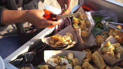 Spring rolls or "lumpia" traders are cutting green chilies. Vidéo 199763222