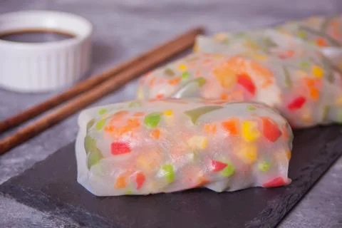 Spring rolls with vegetables and rice paper on the black plate Stock Photos