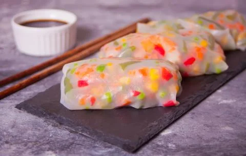 Spring rolls with vegetables and rice paper on the black plate Stock Photos