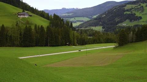 Spring rural landscape of alpine meadow road and driving car in Dolomites Alps Stock Footage 271233106