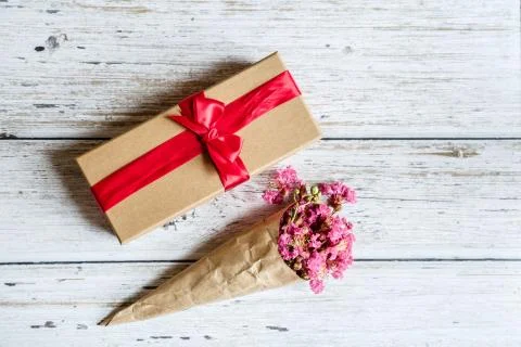 Spring Rustic background with gift box and pink flowers. Copy space on white  Stock Photos