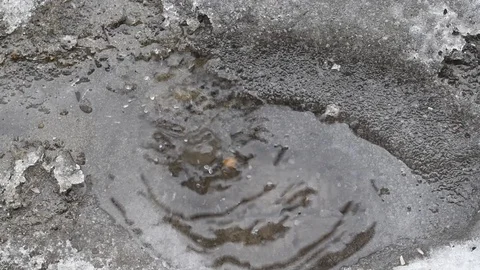 In the spring, the snow melts into water, forming pools with splashes. Stock Footage 111499799