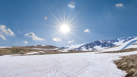 Spring snowbound mountains under a sparkle sun Stock Footage 329178275