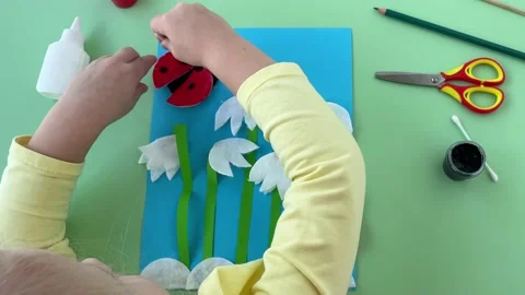 Spring snowdrops made of cotton pads. using a cotton swab, girl put black dots Stock Footage 236246056