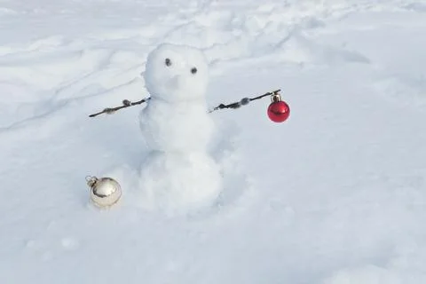 Spring snowman with willow branches and Christmas tree decorative balls on snow Stock Photos