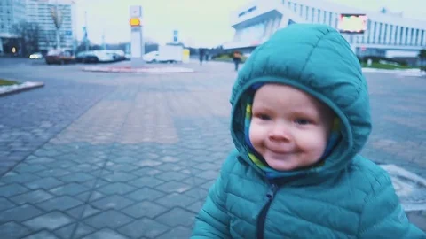 Spring. Steadicam shot of kid running down the sidewalk, grass and melting snow 스톡 동영상 83481155