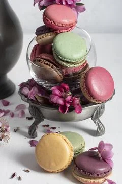 Spring still life with colored macaroons and pink apple tree flowers in a pewter Stock Photos