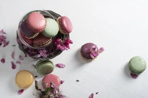 Spring still life with colored macaroons and pink apple tree flowers in a pewter Stock Photos