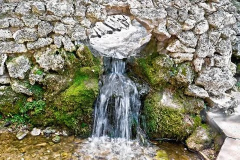Spring from stone gutter Stock Photos