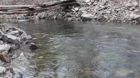 Spring stream with floating pieces of ice and with small bridge Stock Footage 63790721