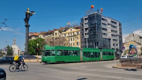 Spring sunlight brightens central Sofia as a green Basel tram glides past the Stock-Footage 316130694