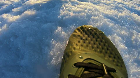 Spring . Sunset. A man strolls along the snowy road. Legs . Human . Stock Footage 88663952