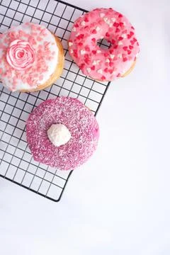 Spring sweets pink donuts with decorations on white background Stock Photos