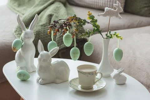Spring Table Decor with Bunny Figurines, Hanging Eggs and Floral Cup of Coffe Stock Photos