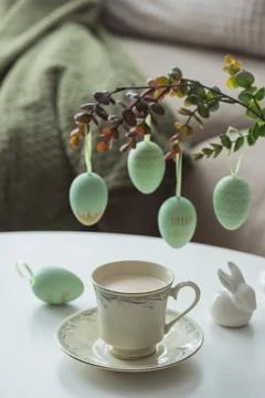 Spring Table Decor with Bunny Figurines, Hanging Eggs and Floral Cup of Coffe Stock Photos