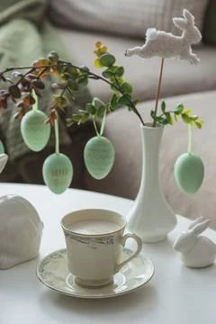 Spring Table Decor with Bunny Figurines, Hanging Eggs and Floral Cup of Coffe Stock Photos