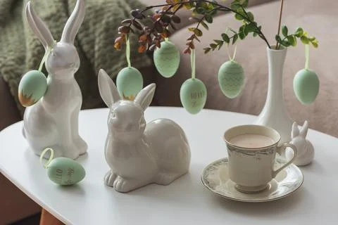 Spring Table Decor with Bunny Figurines, Hanging Eggs and Floral Cup of Coffe Stock Photos