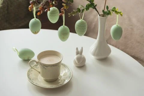 Spring Table Decor with Bunny Figurines, Hanging Eggs and Floral Cup of Coffe Stock Photos