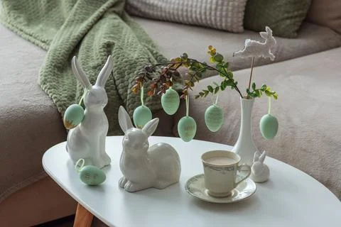 Spring Table Decor with Bunny Figurines, Hanging Eggs and Floral Cup of Coffe Stock Photos