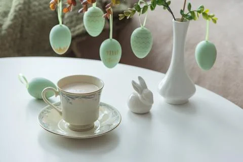 Spring Table Decor with Bunny Figurines, Hanging Eggs and Floral Cup of Coffe Stock Photos