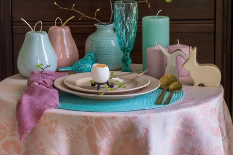 Spring table set for Easter - a chicken egg and a twig with the first leaves on Stock Photos