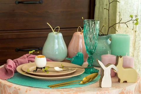 Spring table set for Easter - a chicken egg and a twig with the first leaves on Stock Photos